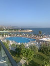 High angle view of swimming pool by sea against clear sky