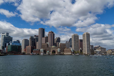 Sea by cityscape against sky