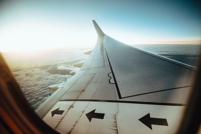 Close-up of airplane wing against sky