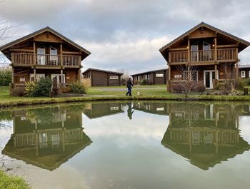 Reflection of building on lake against sky