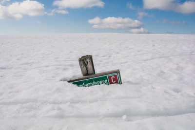 Information sign on land against sky during winter