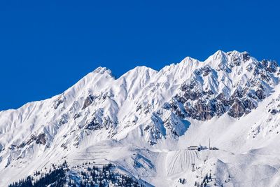 Scenic view of snowcapped mountains against clear blue sky