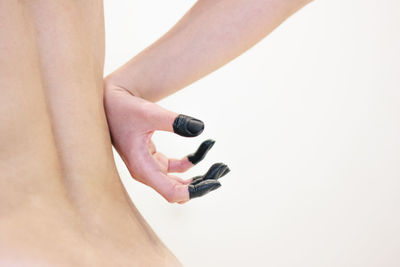 Close-up of woman holding hand over white background