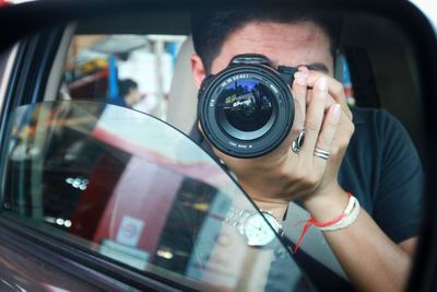 Portrait of man photographing car