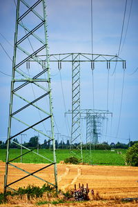 Electricity pylon on field against sky