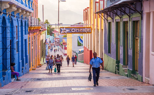 People walking on street amidst buildings in city