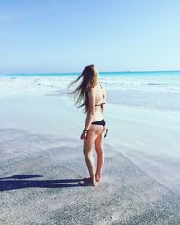 Full length of woman standing on beach against sky