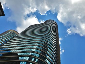 Low angle view of modern building against cloudy sky