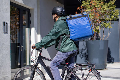 Delivery person on electric bicycle arriving to destination