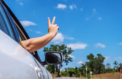 Midsection of person with umbrella against sky