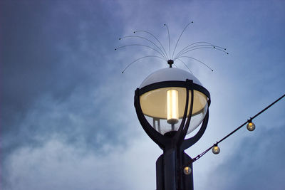 Low angle view of illuminated street light against sky