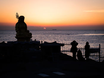 Silhouette of woman at seaside during sunset