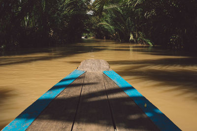 Wooden rowboat in river at forest