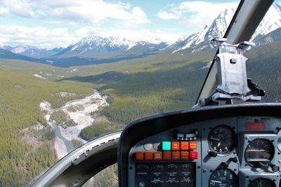 Airplane flying over snowcapped mountains against sky