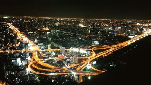 Aerial view of illuminated cityscape against sky at night