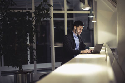 Rear view of man using laptop