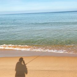 People on beach by sea against sky