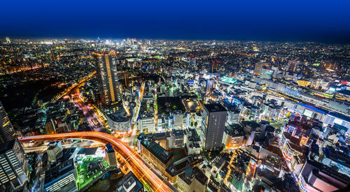 Aerial view of highway amidst buildings in city at night