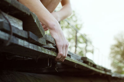 Low section of man on wooden plank outdoors