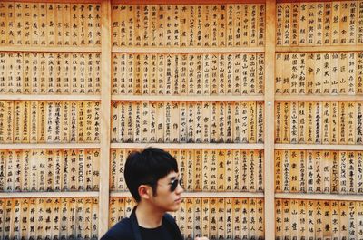 Portrait of young man looking away against wall