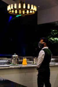 Rear view of man standing in cafe