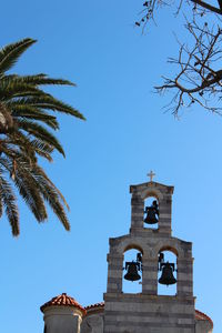 Low angle view of bell tower against blue sky