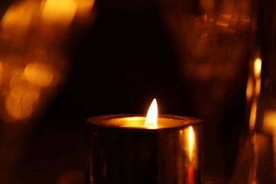 Close-up of lit candle in darkroom