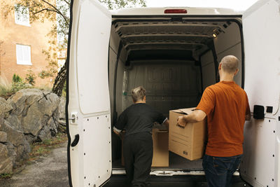 Couple putting boxes into van