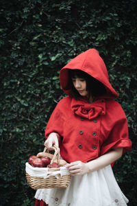 Midsection of woman holding red basket