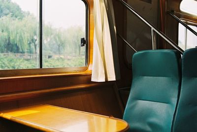 Empty chairs by table in train