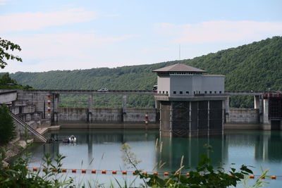 Built structure by lake against sky