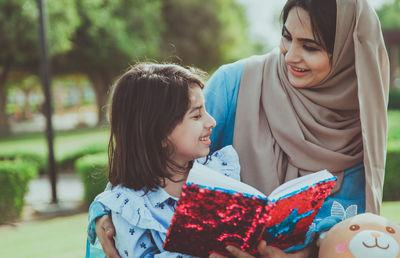 Mother with cheerful daughters enjoying at park