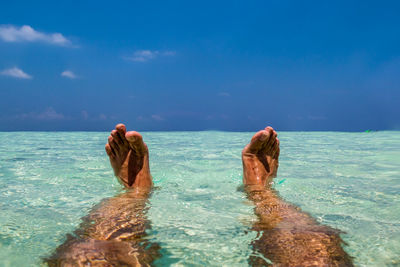 Low section of person relaxing in sea