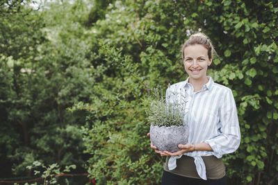 Portrait of smiling man standing against plants