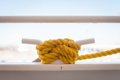 Close-up of yellow rope on railing