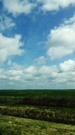 Scenic view of field against cloudy sky