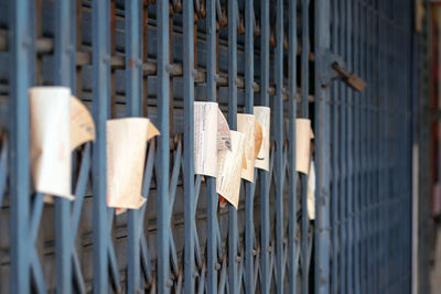 Close-up of paper hanging on metal gate
