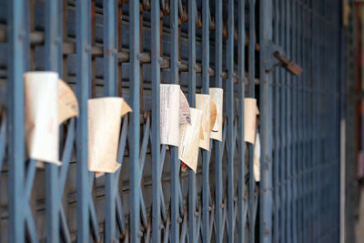 Close-up of clothes hanging on metal fence