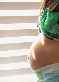 Rear view of woman standing against wall