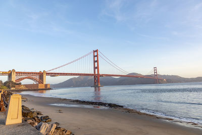 Suspension bridge over sea against sky