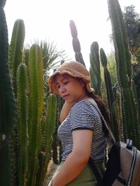 Cute boy on cactus plant against sky