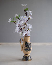 A branch of a blossoming apple in a vase with a pattern