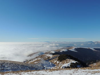 Scenic view of snowcapped mountains against clear blue sky