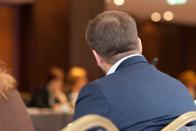 Rear view of businessman sitting on chair in conference