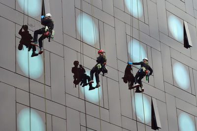 Low angle view of people working on building