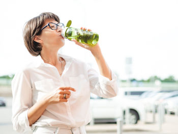 Young woman drinking water bottle