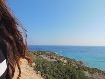 Woman looking at sea against clear sky