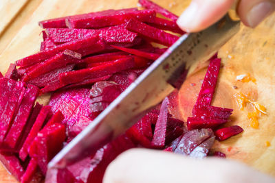 Cropped hand cutting beetroots