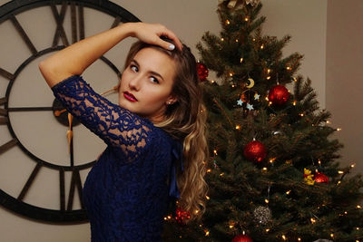 Portrait of young woman with christmas tree