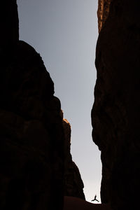 Low angle view of silhouette rock formations against sky